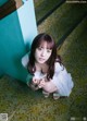 A woman in a white dress crouching down on the stairs.