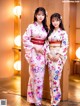 Two young women in kimonos standing next to each other.