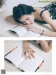 A woman laying on the floor reading a book.