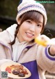 A woman holding a plate of food with a smile on her face.