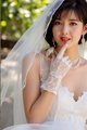 A woman in a wedding dress and gloves posing for a picture.